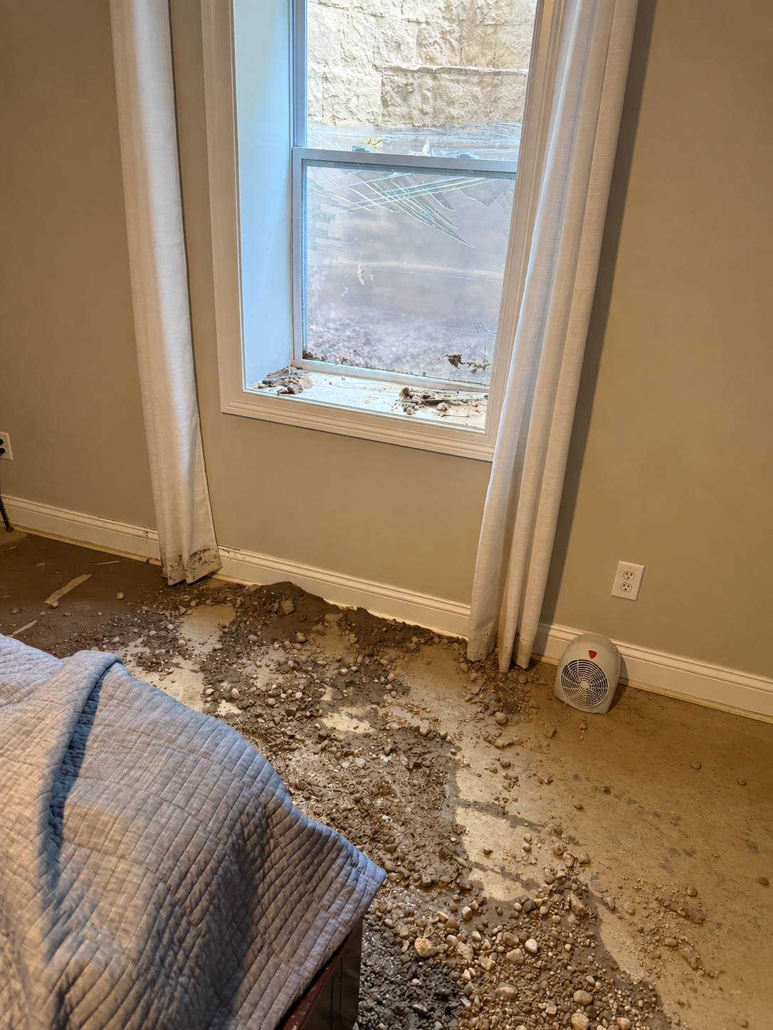 Interior flood damage around broken basement window before replacement in Centerville Ohio