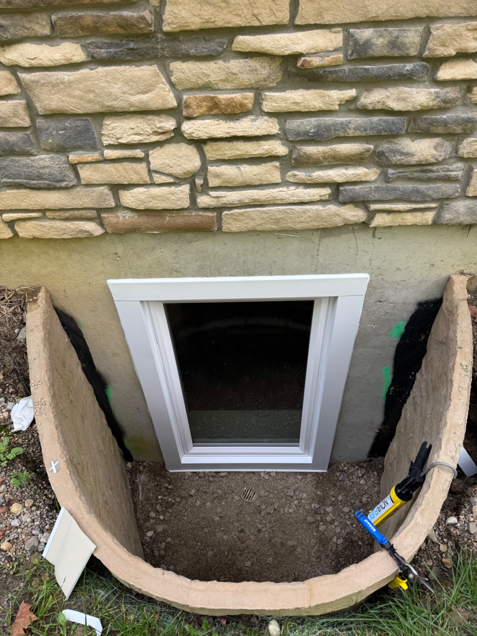 New white casement egress window installed in basement window well in Centerville Ohio